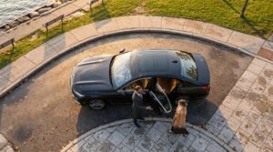Chauffeur welcoming an executive passenger beside a luxury saloon for the best Pickering Pearson limo transfer outside an upscale waterfront district.