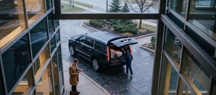 Chauffeur placing luggage into the boot of an executive vehicle showcasing transparent Pickering Pearson limo prices.